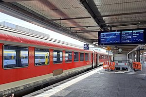 Bahnsteig mit alten Intercity-Wagen, die in DB-Regio-Rot lackiert sind.