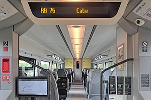 Innenraum des Zuges, schwarze Sitze mit gelbem Baden-W&uuml;rttemberg-L&ouml;wen, Deckenanzeige 'RB 76 Calw', links ein Monitor mit Informationen zur Fahrt.