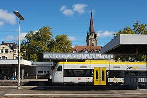 gelb-weißes Regio-Shuttle im Bahnhof, im Hintergrund Kirchturm